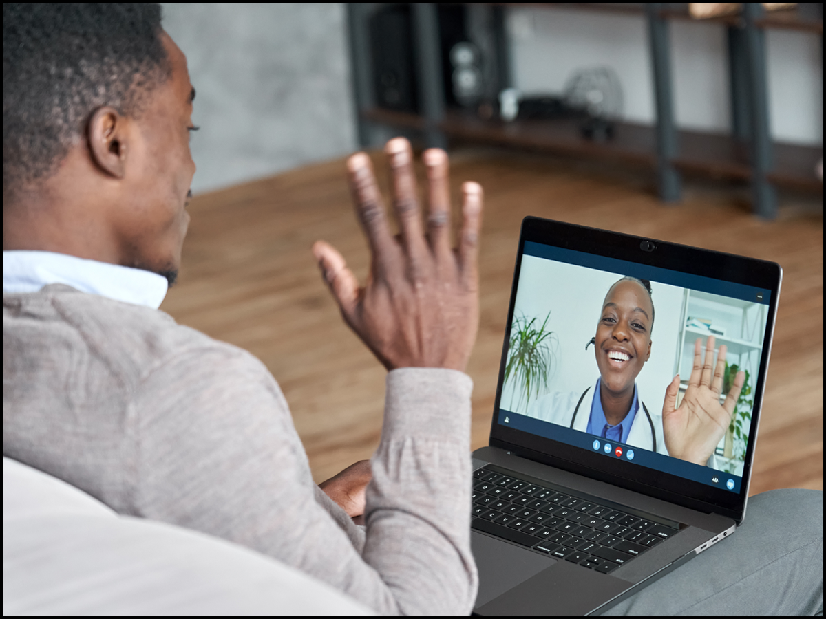 Black male presenting person meeting with their black female presenting doctor on a laptop